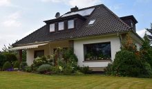 Ein Einfamilienhaus mit grauem Dach und einem gepflegten Garten - Notverkauf