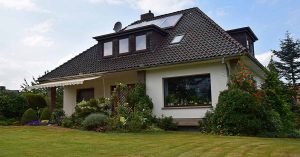 Ein Einfamilienhaus mit grauem Dach und einem gepflegten Garten - Notverkauf